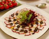 A picture of step 6 of Octopus Carpaccio in extra virgin oil oil and paprika powder.