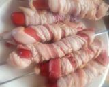 A picture of step 2 of Deep-Fried, Bacon-Wrapped Hot Dogs on Skewers.