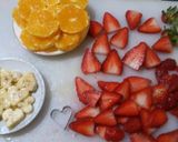 A picture of step 8 of Kunafa and Qashtalia Decorated with Oranges, Strawberries, and Bananas.