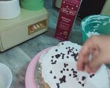 A picture of step 4 of Vanilla cream cake with chocolate chips inside.