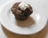 A picture of step 8 of COCONUT MUFFINS with blue berries and chocolate chips.