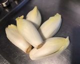 A picture of step 1 of Endive Salad with Cucumber and Red Onion in Chive Dressing.