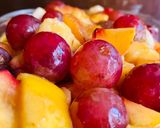 A picture of step 4 of Fruit Salad with Grapes 🍇 banana 🍌, apple 🍎, peach 🍑 & mango 🥭.