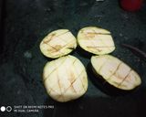 A picture of step 1 of Stuff Brinjal with potato wedges.