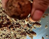 A picture of step 6 of Wheat flour seeds and nuts Ladoo with leftover ghee residue.