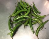 Une image de l'étape 1 de Piments verts indiens confits à l'ail, herbes et citron.