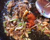 A picture of step 6 of Paella with Secreto Pork, Mushrooms, and Green Garlic.