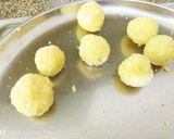 A picture of step 10 of Coconut Mawa balls immersed in Creamy Coconut saffron milk.