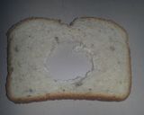 A picture of step 2 of French toast with an egg in the middle..
