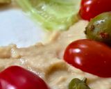 Foto del paso 5 de la receta: Corona navideña express de hummus 🎄Hummus decorado con tomatitos, olivas, pepino y alcaparras 🎄