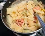 A picture of step 3 of Mix pasta in white sauce.