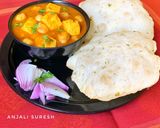 A picture of step 11 of Chana Paneer with Kasoori methi flavoured Bhaturas.