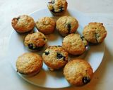 A picture of step 7 of COCONUT MUFFINS with blue berries and chocolate chips.