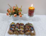 A picture of step 5 of Banana cinnamon bread rolls with chocolate syrup garnish.