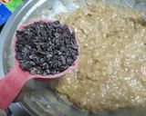 A picture of step 6 of Easy Banana bread with cocoa nibs and blueberries.