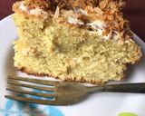 A picture of step 8 of Coconut cake topped with caramelized coconut flakes.