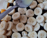 Foto del paso 3 de la receta: Postre multifruta (banana, naranja, durazno, frutillas, uvas pasa) con leche condensada casera