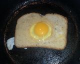 A picture of step 3 of French toast with an egg in the middle..