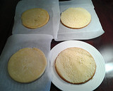 A picture of step 6 of White Butter Cake layered with Raspberry Cream with a White Chocolate Frosting.