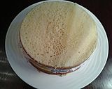 A picture of step 9 of White Butter Cake layered with Raspberry Cream with a White Chocolate Frosting.