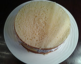A picture of step 9 of White Butter Cake layered with Raspberry Cream with a White Chocolate Frosting.