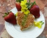 A picture of step 10 of Kunafa and Qashtalia Decorated with Oranges, Strawberries, and Bananas.