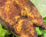 A picture of step 12 of Baked Tilapia Fish served with rocket leaves.