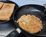 A picture of step 4 of Schezwan chutney brown Bread 🍞 tomato 🍅 onion omellete.