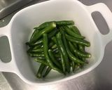 Une image de l'étape 2 de Piments verts indiens confits à l'ail, herbes et citron.