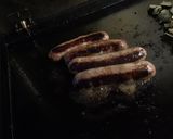 Une image de l'étape 6 de Saucisses de Toulouse grillées courgette épicée et herbes aromatiques.