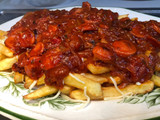Salchichas con patatas fritas, tomate y queso