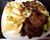 A picture of step 4 of Ribeye Steak onions and mushrooms. With homemade Chips 😀.