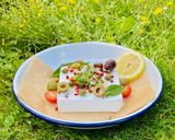 A picture of step 3 of Baked Vegan Feta with olives, pink peppercorns, lemon and summer herbs and veggies 🌱.