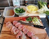 A picture of step 2 of Asian style pork kebabs, steamed veg and yellow rice.