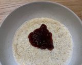 A picture of step 2 of Porridge with blueberries and strawberry jam.