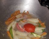 A picture of step 1 of Veg clear soup with sliced boiled egg.