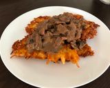 A picture of step 10 of Beef goulash with mushrooms served on potato pancakes.