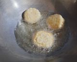 A picture of step 4 of Coconut fritters deep in sugar syrup.