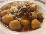 Ñoquis de batata rellenos con muzzarella y salsa bolognesa
