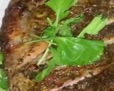 A picture of step 11 of Baked Tilapia Fish served with rocket leaves.