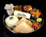 A picture of step 4 of Kathiyawadi Lunch Thali (Dahi Tikhari, Sev Tameta Nu Shak, Dal Bhaat, Fulka Rotli, Chaas, Papad).