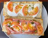 A picture of step 4 of Focaccia bread with Mortadella, grilled tomatoes, melted mozzarella and cornichons.