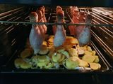 Курячі гомілки на решітці з картоплею в деко