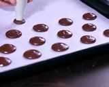 A picture of step 5 of Chocolate Macarons with a White Chocolate Ganache filling.