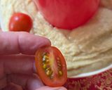 Foto del paso 3 de la receta: Corona navideña express de hummus 🎄Hummus decorado con tomatitos, olivas, pepino y alcaparras 🎄