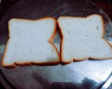 A picture of step 1 of Halloween spooky bread sandwich with tomato sauce.