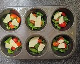 A picture of step 1 of Egg Cups With Tomato, Swiss, and Spinach.
