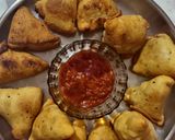 A picture of step 17 of Samosa with spicy red chutney.