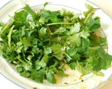 A picture of step 2 of Fried rice topped with green veggies.