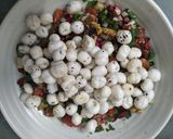 A picture of step 5 of Healthy Makhaana Salad with fruits veggies and nuts.
